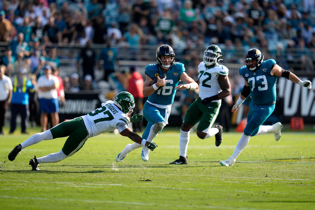 Jacksonville Jaguars quarterback Trevor Lawrence (16) runs with ball against New York Jets cornerback Qwan'Tez Stiggers (37) during the first half of an NFL football game, Sunday, Dec. 14, 2025, in Jacksonville, Fla. (AP Photo/John Raoux)