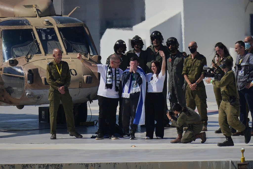 Matan Angrest, an Israeli hostage released from the Gaza Strip puts his hands on his face after coming off a helicopter at the Ichilov Hospital, in Tel Aviv, Israel, Monday, Oct. 13, 2025. (AP Photo/Ohad Zwigenberg)