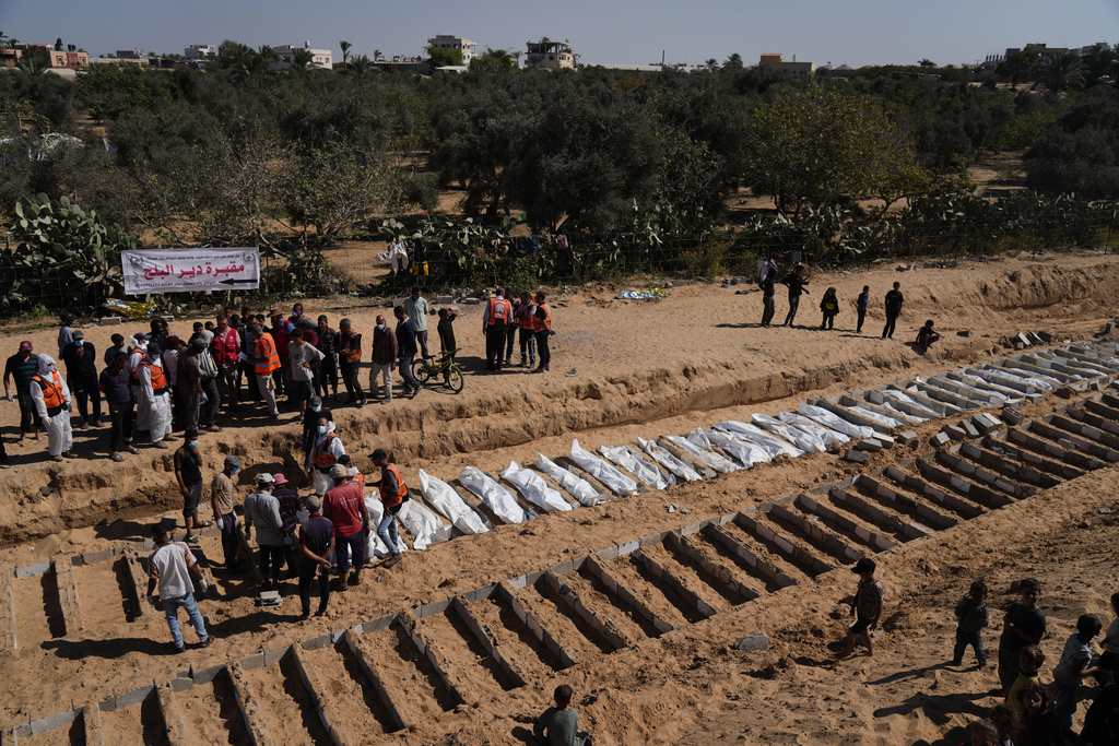 Bodies of unidentified Palestinians returned from Israel are buried in a mass grave in Deir al-Balah, Gaza Strip, Monday, Oct. 27, 2025. (AP Photo/Jehad Alshrafi)