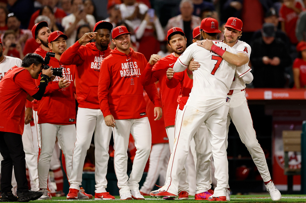 Los Angeles Angels Jo Adell (7) is greeted by teammates at the end of a baseball game against the Seattle Mariners, Saturday, April 4, 2026, in Anaheim, Calif. (AP Photo/Caroline Brehman)
