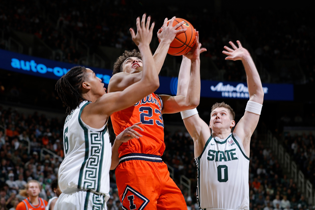 Illinois guard Keaton Wagler (23) looks to shoot between Michigan State forwards Jordan Scott (6) and Jaxon Kohler (0) during the first half of an NCAA college basketball game, Saturday, Feb. 7, 2026, in East Lansing, Mich. (AP Photo/Al Goldis)