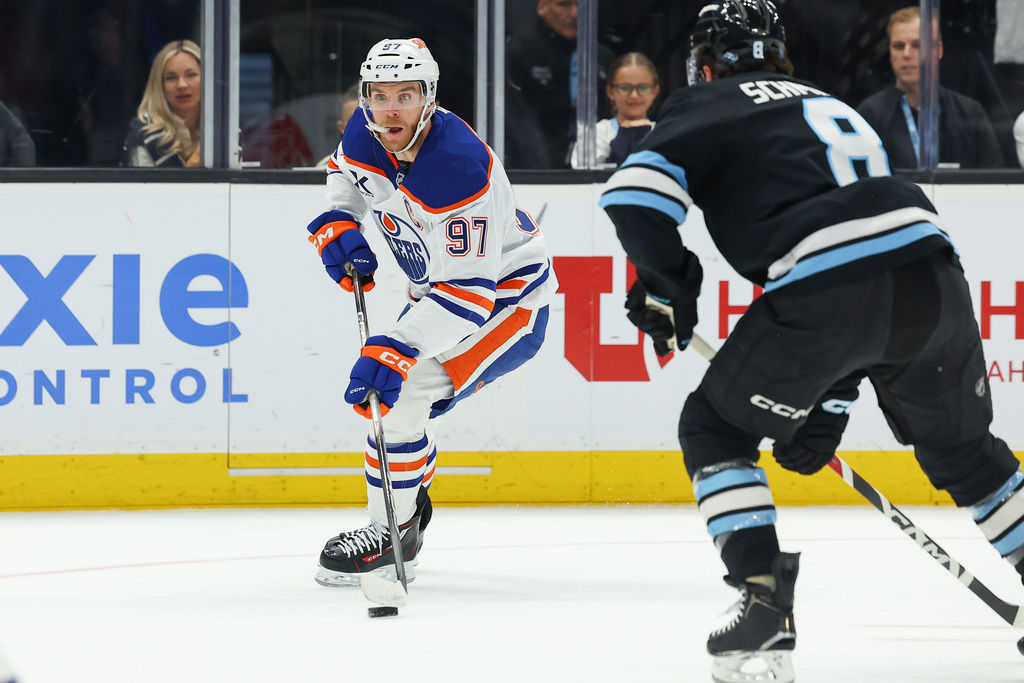 Edmonton Oilers center Connor McDavid (97) controls the puck against Utah Mammoth center Nick Schmaltz (8) during the first period of an NHL hockey game, Tuesday, March 24, 2026, in Salt Lake City. (AP Photo/Melissa Majchrzak)