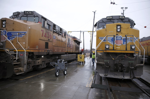 FILE - A Union Pacific worker walks between two locomotives that are being serviced in a railyard in Council Bluffs, Iowa, on Dec. 15, 2023. Union Pacific reports earnings on Thursday, April 25, 2024. (AP Photo/Josh Funk)