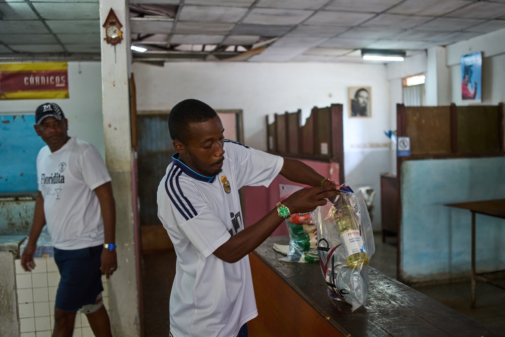 State-run bodega manager Roberto Roman fills bags with donated Mexican humanitarian assistance to be delivered to a family, in Havana, Cuba, Thursday, Feb. 19, 2026. (AP Photo/Ramon Espinosa)