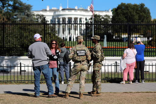 FILE - People talk with National Guard soldiers on the Ellipse, with the White House in the background, Oct. 17, 2025, in Washington. (AP Photo/Rahmat Gul, File) FILE - People talk with National Guard soldiers on the Ellipse, with the White House in the background, Oct. 17, 2025, in Washington. (AP Photo/Rahmat Gul, File)