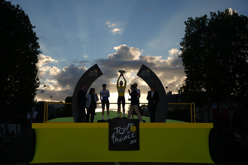 Slovenia's Tadej Pogacar, wearing the overall leader's yellow jersey, celebrates on the podium with Belgium's Remco Evenepoel, left, who finished second, and Mexico's Isaac Del Toro, right, who came third, after the last stage of the Tour de France cycling race with start and finish in Paris, Sunday, July 26, 2026. (AP Photo/Mosa'ab Elshamy)