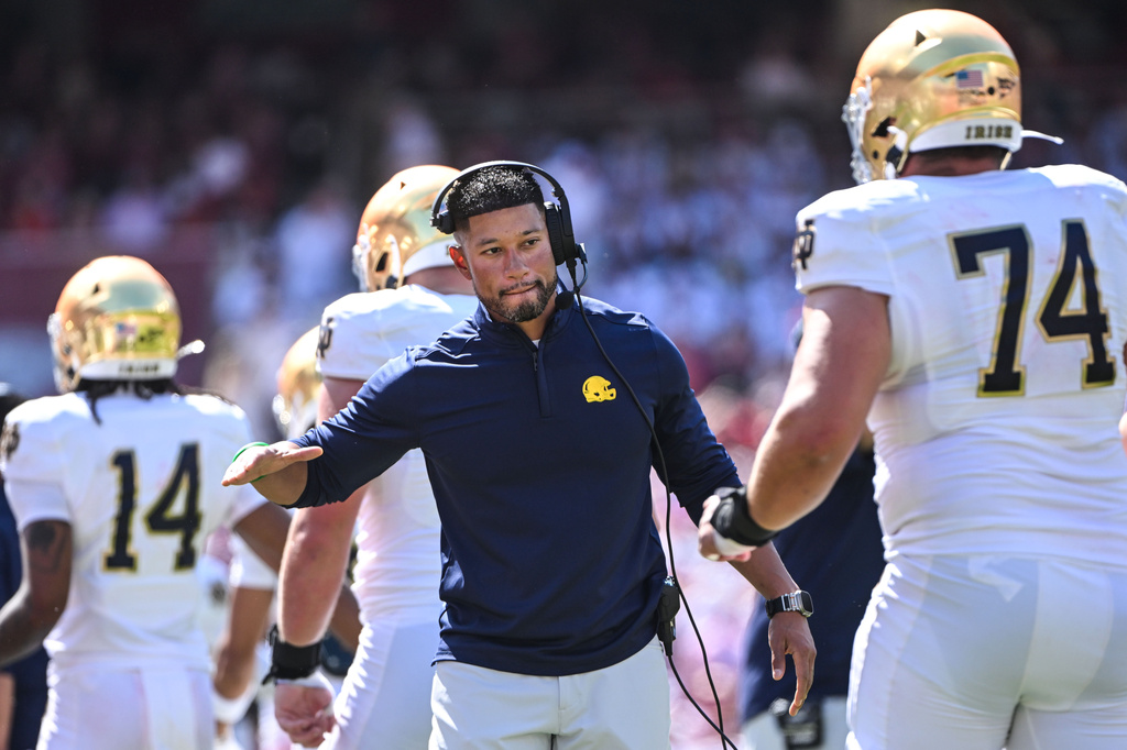 FILE - Notre Dame coach Marcus Freeman shakes hands with his players as they come off the field after scoring a touchdown against Arkansas during an NCAA college football game Sept. 27, 2025, in Fayetteville, Ark. (AP Photo/Michael Woods, File)