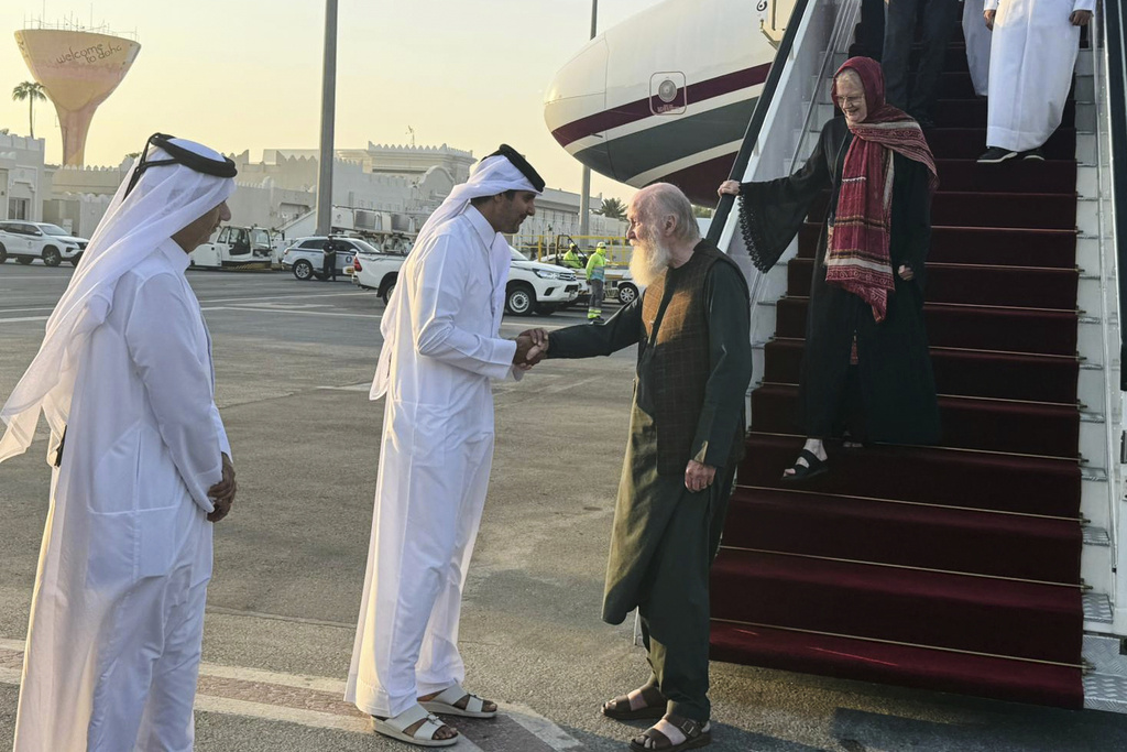 A Qatari official welcomes the released British couple, Barbie and Peter Reynolds, as they step off the plane upon their arrival in Doha, Qatar, Friday, Sept. 19, 2025. (AP Photo/Najib Jubain)