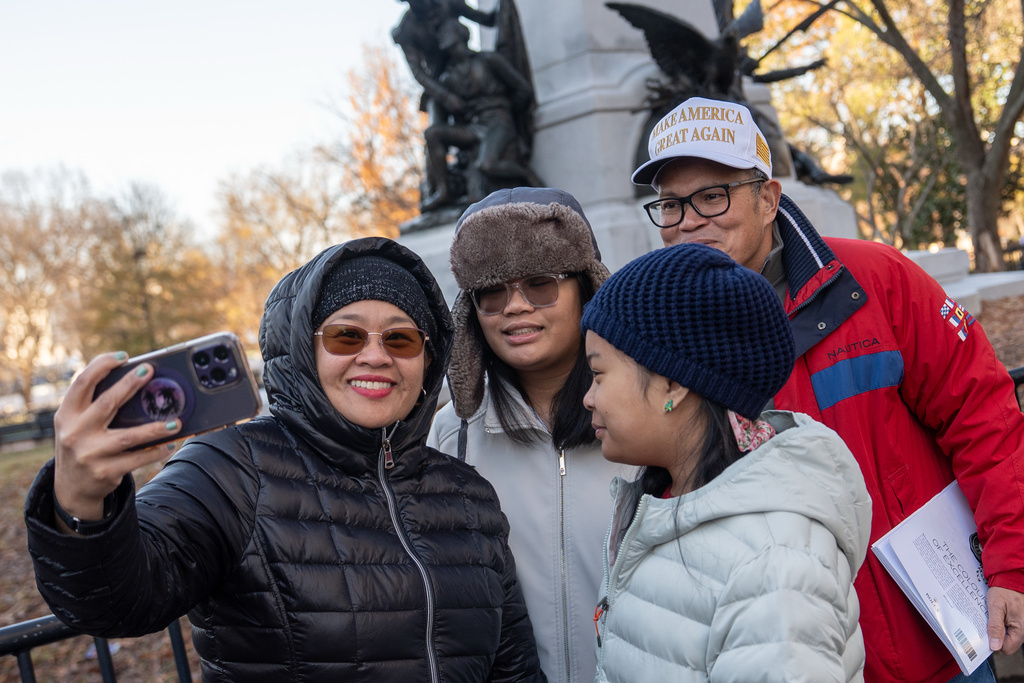 People take a selfie as they wait in line for a White House tour, Wednesday, Dec. 3, 2025, in Washington, as tours resume for the first time since construction of a new ballroom began at the White House. (AP Photo/Julia Demaree Nikhinson)