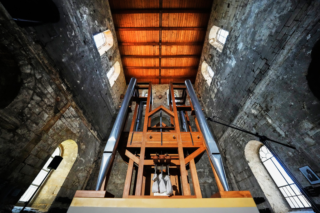 The organ, center, of the John Cage Organ Project Halberstadt is illuminated prior to a chord change of the organ inside the medieval Burchardi Church in Halberstadt, Germany, Wednesday, Aug. 5, 2026. (AP Photo/Markus Schreiber)