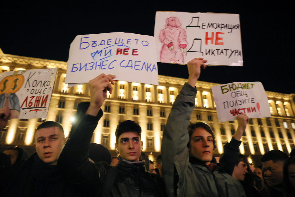 People hold posters read from left: "How many more lies?", "The future is not a business deal", "Democracy is not a dictatorship" and "The budget is public, the benefits are private" during a rally against austerity measures in next year's draft budget, in Sofia, Monday, Dec 1, 2025. (AP Photo/Valentina Petrova)