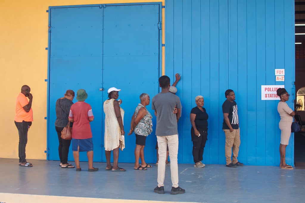 People wait to vote at a polling station during the general election in Bridgetown, Barbados, Wednesday, Feb. 11, 2026. (AP Photo/Kerrie Eversley)