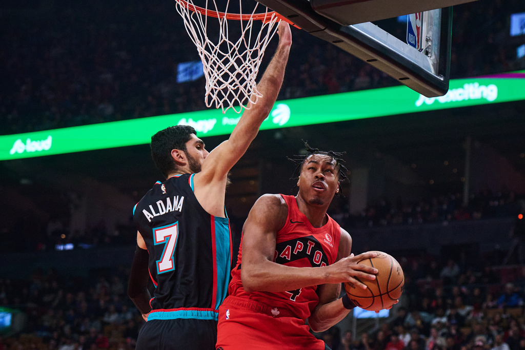 Toronto Raptors' Scottie Barnes, right, drives to the net past Memphis Grizzlies' Santi Aldama (7) during first-half NBA basketball game action in Toronto, Sunday, Nov. 2, 2025. (Sammy Kogan/The Canadian Press via AP)