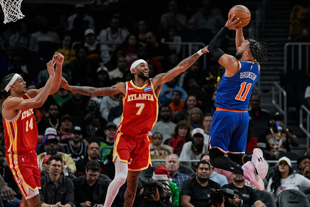 New York Knicks guard Jalen Brunson (11) shoots against Atlanta Hawks guard Nickeil Alexander-Walker (7) during the first half of an NBA basketball game, Saturday, Dec. 27, 2025, in Atlanta. (AP Photo/Mike Stewart)