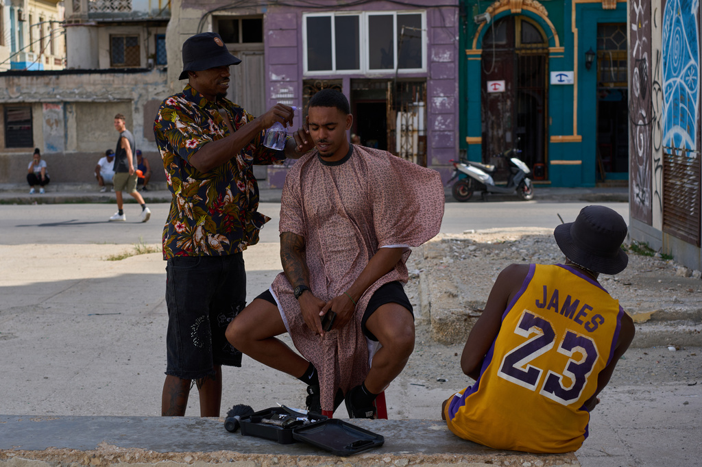A barber provides service to a client on a street during a blackout in Havana, Cuba, Friday, Sept. 18, 2026. (AP Photo/Ramon Espinosa)