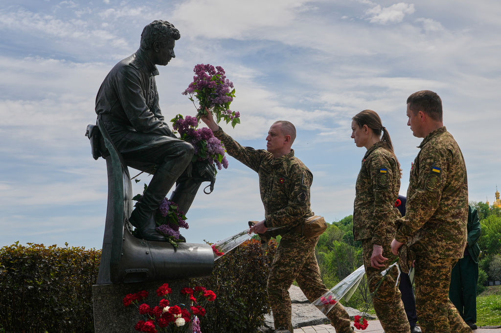 Ukrainian army officers lay flowers at a monument to pilots to mark Victory Day in World War II, in Kyiv, Ukraine, Friday, May 8, 2026, as the Russian attack on Ukraine continues. (AP Photo/Efrem Lukatsky)