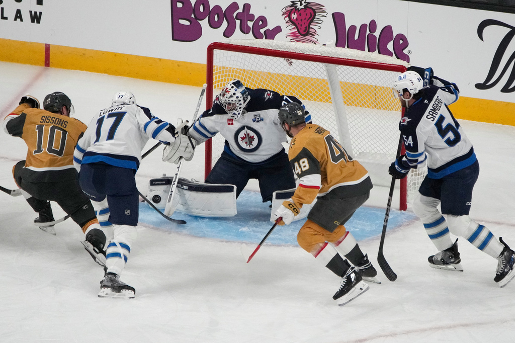 Winnipeg Jets goaltender Connor Hellebuyck (37) stops a shot attempt by the Vegas Golden Knights during the first period of an NHL hockey game Monday, April 13, 2026, in Las Vegas. (AP Photo/John Locher)