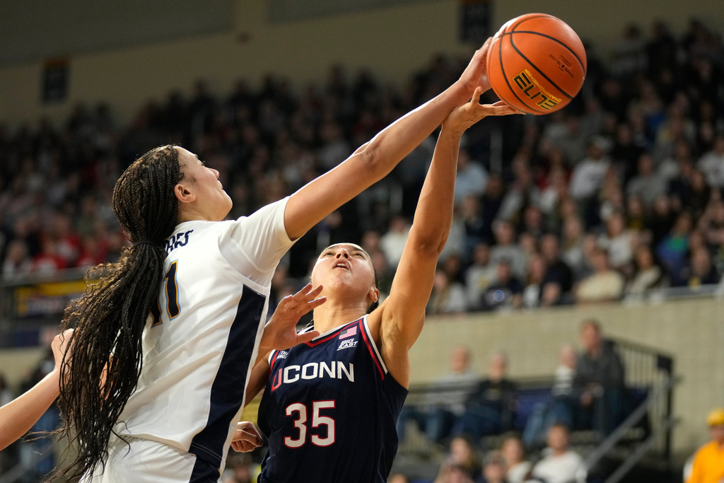 Marquette forward Skylar Forbes (11) blocks a shot by UConn guard Azzi Fudd (35) during the first half of an NCAA college basketball game Saturday, Feb. 14, 2026, in Milwaukee. (AP Photo/Kayla Wolf)