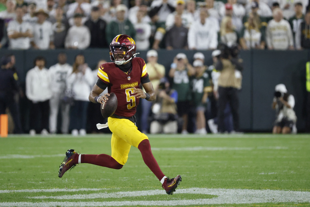 Washington Commanders quarterback Jayden Daniels scrambles during the first half of an NFL football game against the Green Bay Packers Thursday, Sept. 11, 2025, in Green Bay, Wis. (AP Photo/Mike Roemer)