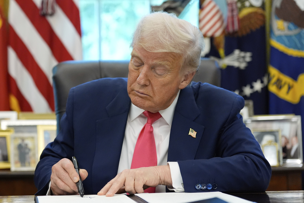 President Donald Trump signs a proclamation in the Oval Office honoring the 90th anniversary of the Social Security Act, Thursday, Aug. 14, 2025, in Washington. (AP Photo/Alex Brandon)