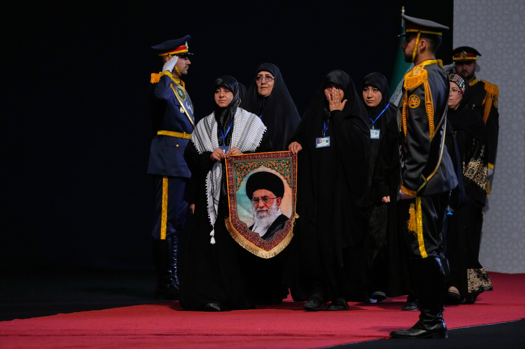 Women carry a portrait of slain Iranian Supreme Leader Ayatollah Ali Khamenei as they arrive to pay their respects before the coffins of Khamenei and members of his family during a viewing ceremony ahead of the dayslong funeral ceremonies at the Imam Khomeini Mosalla Grand Mosque in Tehran, Iran, Friday, July 3, 2026. (AP Photo/Vahid Salemi)