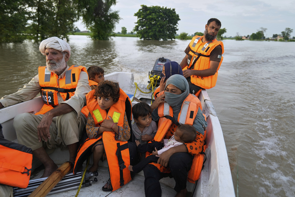 A rescue worker evacuates villagers from a flooded area in Dhoop Sarhi village in Kasur district, Pakistan, Tuesday, Aug. 26, 2025, due to the rising water level in Sutlej River, following neighboring India releasing water from overflowing dams. (AP Photo/K.M. Chaudary)