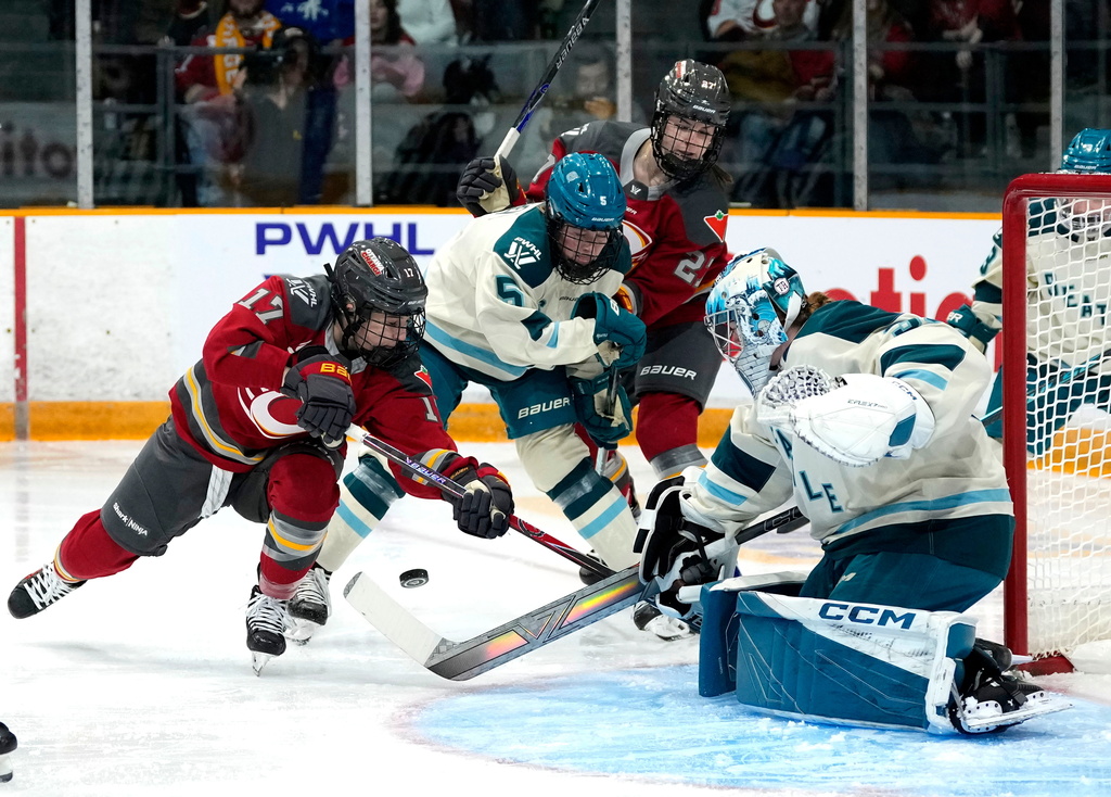 Ottawa Charge's Gabbie Hughes (17) looks for a chance on the rebound on Seattle Torrent goaltender Corinne Schroeder (30) as Anna Wilgren (5) defends against Charge's Brooke McQuigge (27) during first period PWHL hockey action in Ottawa, on Wednesday, Jan. 28, 2026. (Justin Tang/The Canadian Press via AP)