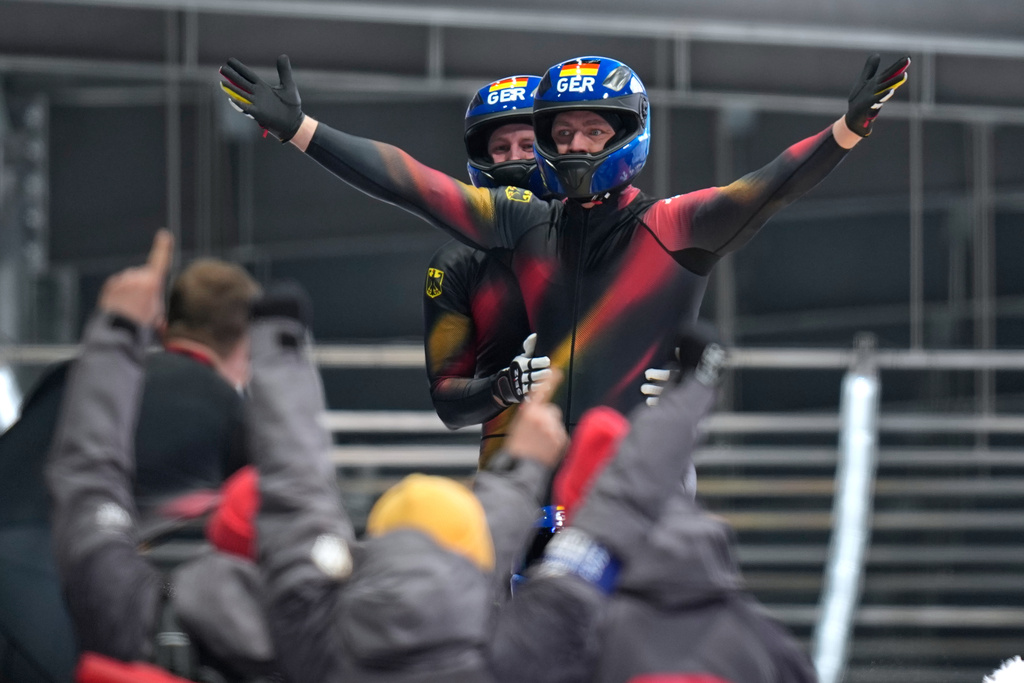 Germany's gold medalists Johannes Lochner, front, Thorsten Margis, Jorn Wenzel and Georg Fleischauer arrive at the finish during a four man bobsled run at the 2026 Winter Olympics, in Cortina d'Ampezzo, Italy, Sunday, Feb. 22, 2026. (AP Photo/Aijaz Rahi)