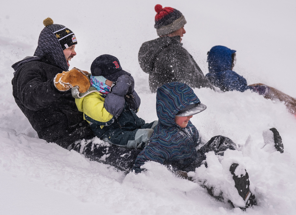 Gordon Vermeer, left, holds on to his daughter Libby Vermeer and her friend, Lewis Hougard, as they sled at Lyndale Farmstead Park during a snow storm Sunday, March 15, 2026, in Minneapolis. (Richard Tsong-Taatarii/Minnesota Star Tribune via AP)
