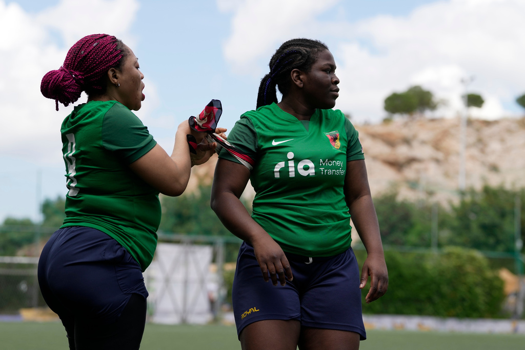 Amelie Nguedia from Cameroon, left, gives the captain's armband after being substituted to Maria Chaffi during a semifinal soccer match against Fostiras Kaisarianis for the Kypseli Mundial in Athens, Greece, on Sunday, May 24, 2026. (AP Photo/Thanassis Stavrakis)
