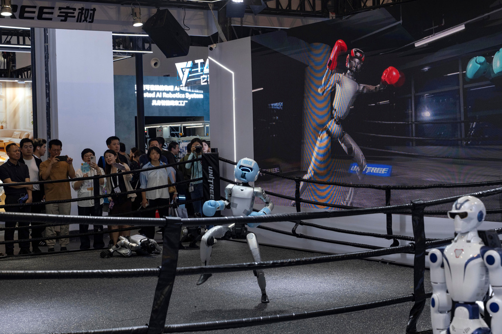 Visitors watch a robot from leading Chinese commercial humanoid robotics firm Unitree Robotics demonstrates it's boxing skills during the World AI Conference in Shanghai, Friday, July 17, 2026. (AP Photo/Ng Han Guan)