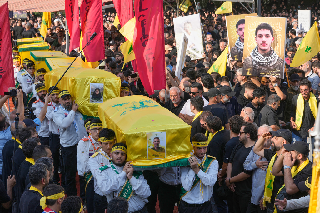 Hezbollah scouts carry the coffins of a Hezbollah member Ali al-Haj Hassan, his wife and his four children, who were killed on Saturday by an Israeli airstrike, during their funeral procession in the southern suburb of Beirut, Lebanon, Sunday, Aug. 16, 2026. (AP Photo/Hussein Malla)