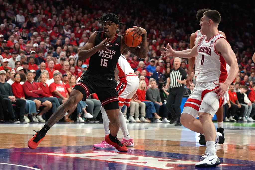 Texas Tech forward JT Toppin drives past Arizona forward Ivan Kharchenkov (8) during the first half of an NCAA college basketball game, Saturday, Feb. 14, 2026, in Tucson, Ariz. (AP Photo/Rick Scuteri)
