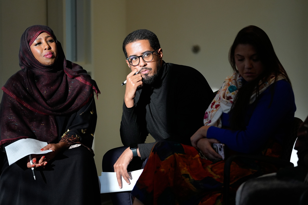 Panelist Mirad Farah, left, and Emory University Ph.D. candidate Ahmed Haji Said, middle, lead a community discussion on vaccine education at Inspire Change Clinic, Nov. 22, 2025, in Minneapolis. (AP Photo/Abbie Parr)