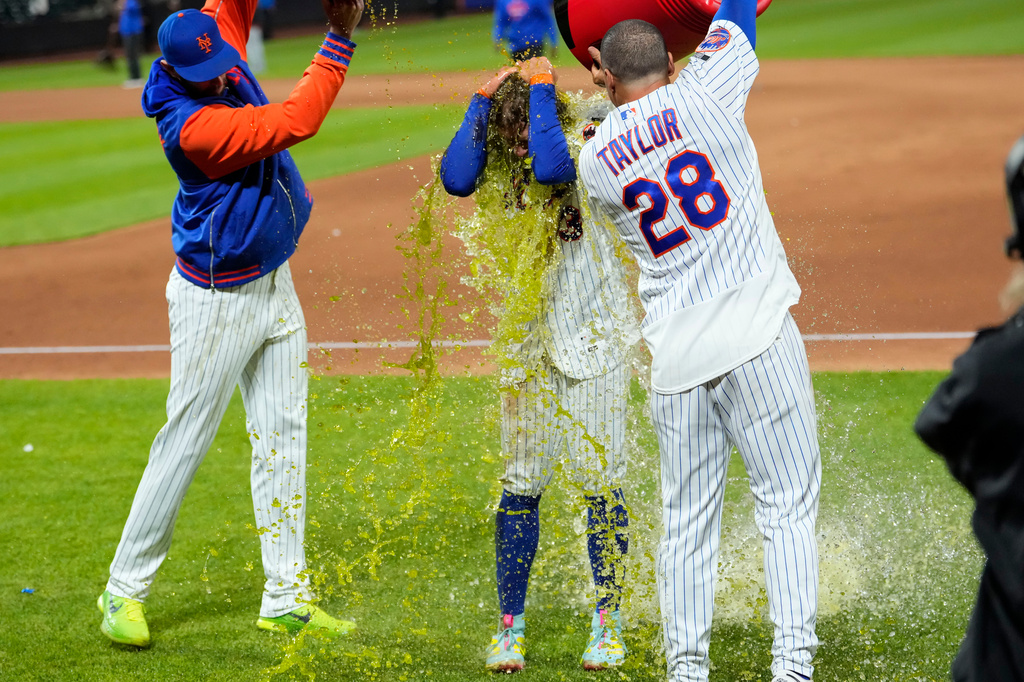 New York Mets' Carson Benge, center, is dunked with gatorade after hitting a walk-off RBI single during the tenth inning of a baseball game against the Detroit Tigers, Wednesday, May 13, 2026, in New York. (AP Photo/Yuki Iwamura)