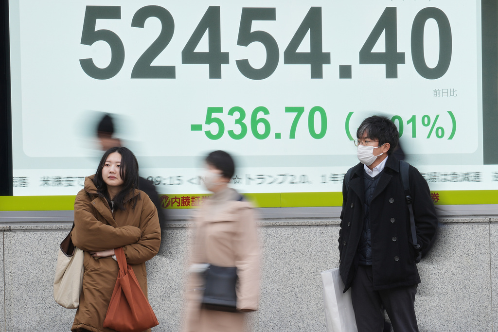 People stand in front of an electronic stock board showing Japan's Nikkei index at a securities firm Wednesday, Jan. 21, 2026, in Tokyo. (AP Photo/Eugene Hoshiko)