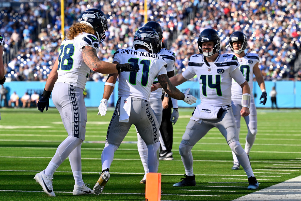Seattle Seahawks wide receiver Jaxon Smith-Njigba (11) celebrates his touchdown pass reception with quarterback Sam Darnold (14) during the second half of an NFL football game against the Tennessee Titans Sunday, Nov. 23, 2025, in Nashville, Tenn. (AP Photo/John Amis)