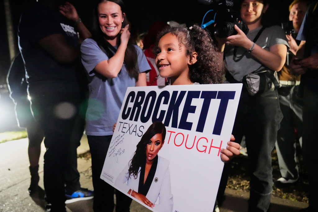 Cataleya Davis holds a poster promoting primary candidate for U.S. Senate Rep. Jasmine Crockett, D-Texas, during a campaign stop in Dallas, Friday, Feb. 27, 2026. (AP Photo/Tony Gutierrez)