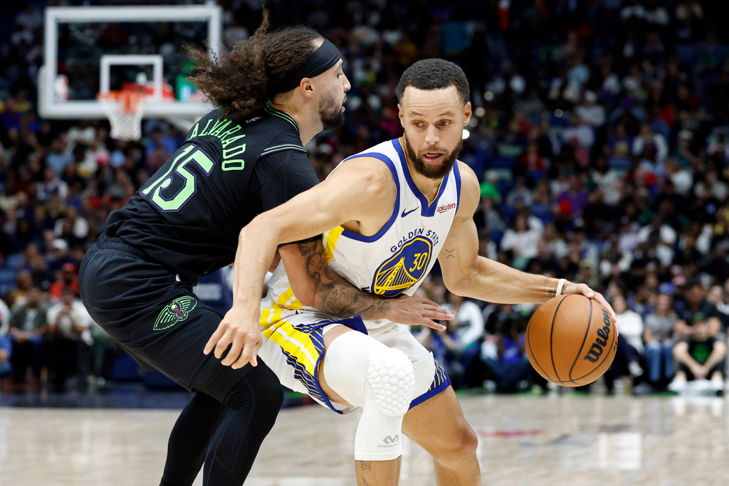 Golden State Warriors guard Stephen Curry (30) dribbles around New Orleans Pelicans guard Jose Alvarado (15) during the second quarter of an NBA basketball game, Sunday, Nov. 16, 2025, in New Orleans. (AP Photo/Butch Dill)