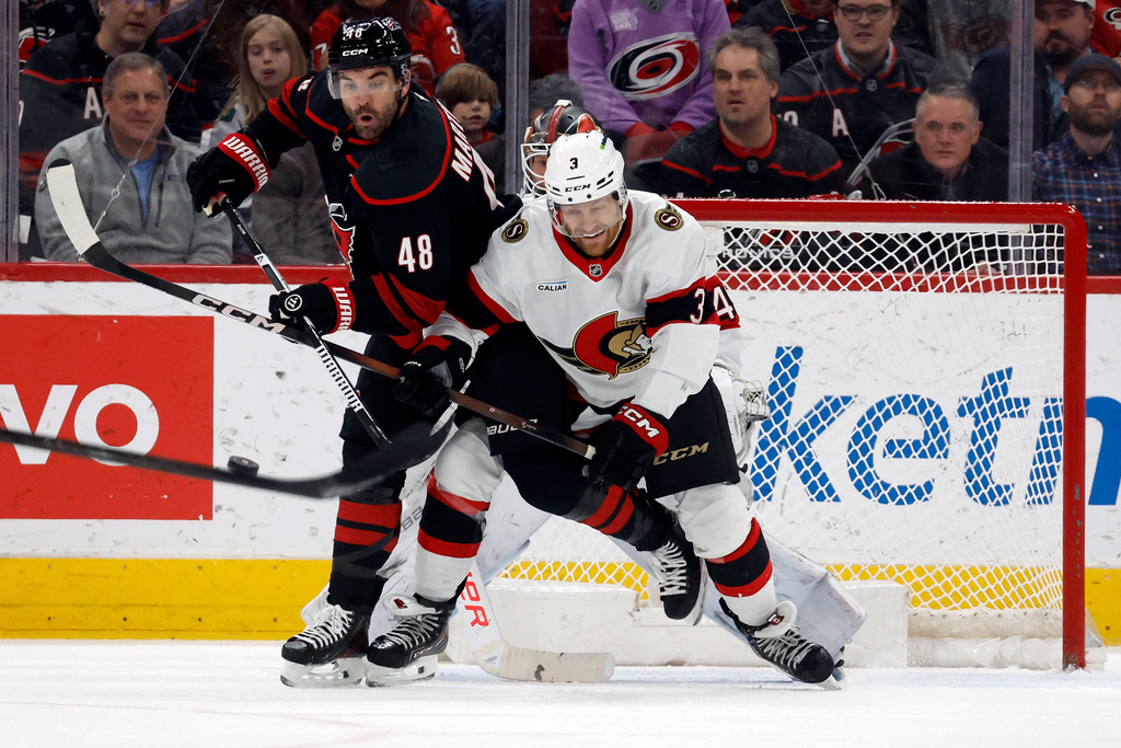 Carolina Hurricanes' Jordan Martinook (48) battles for the puck with Ottawa Senators' Nick Jensen (3) during the first period of an NHL hockey game in Raleigh, N.C., Tuesday, Feb. 3, 2026. (AP Photo/Karl DeBlaker)