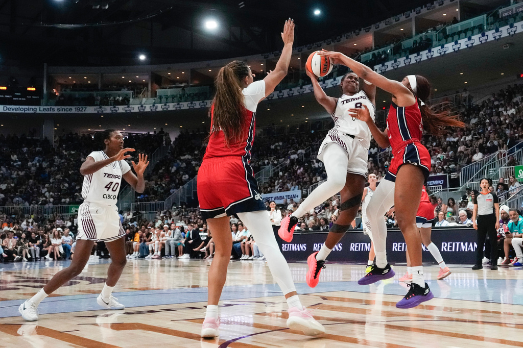 Toronto Tempo's Nyara Sabally, center, drives as Washington Mystics' Cotie McMahon, right, defends during the first half of a WNBA basketball game in Toronto, Tuesday, July 14, 2026. (Chris Young/The Canadian Press via AP)
