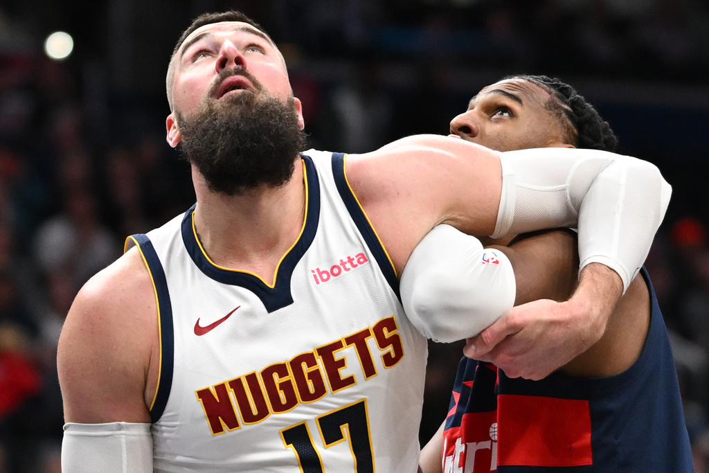 Denver Nuggets center Jonas Valanciunas, left, and Washington Wizards center Alex Sarr, right, compete for a rebound during the first half of an NBA basketball game, Thursday, Jan. 22, 2026, in Washington. (AP Photo/John McDonnell)