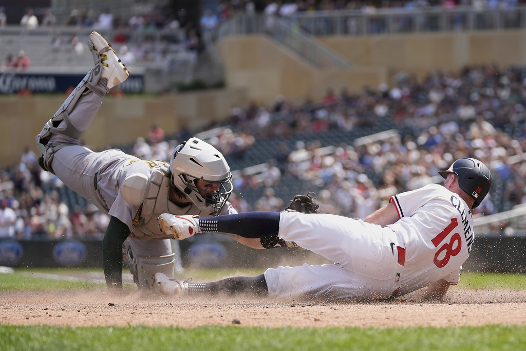 Minnesota Twins' Kody Clemens (18) is tagged out by Athletics catcher Willie MacIver (65) to end the bottom of the fourth inning of a baseball game Thursday, Aug. 21, 2025, in Minneapolis. (AP Photo/Abbie Parr)