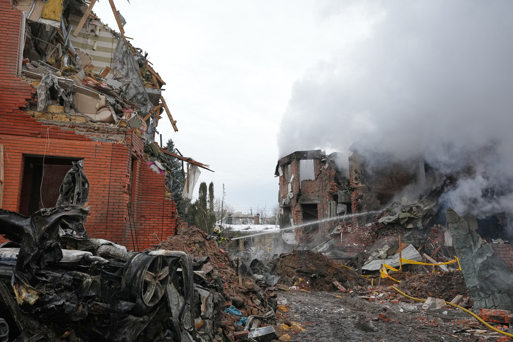Emergency services personnel work to extinguish a fire following a Russian attack in Kyiv, Ukraine, Sunday, Feb. 22, 2026. (AP Photo/Sergei Grits)