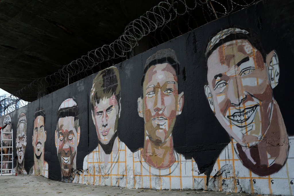 FILE - A mural features the faces of the young soccer players who died in a fire at the Flamengo club training center in Rio de Janeiro, Brazil, Feb. 7, 2020. (AP Photo/Silvia Izquierdo, FILE)