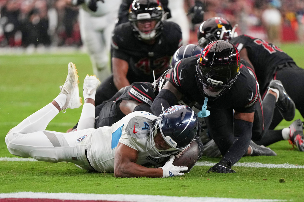 Tennessee Titans wide receiver Tyler Lockett (4) recovers an Arizona Cardinals fumble in the end zone to score a touchdown during the second half of an NFL football game Sunday, Oct. 5, 2025, in Glendale, Ariz. (AP Photo/Rick Scuteri)