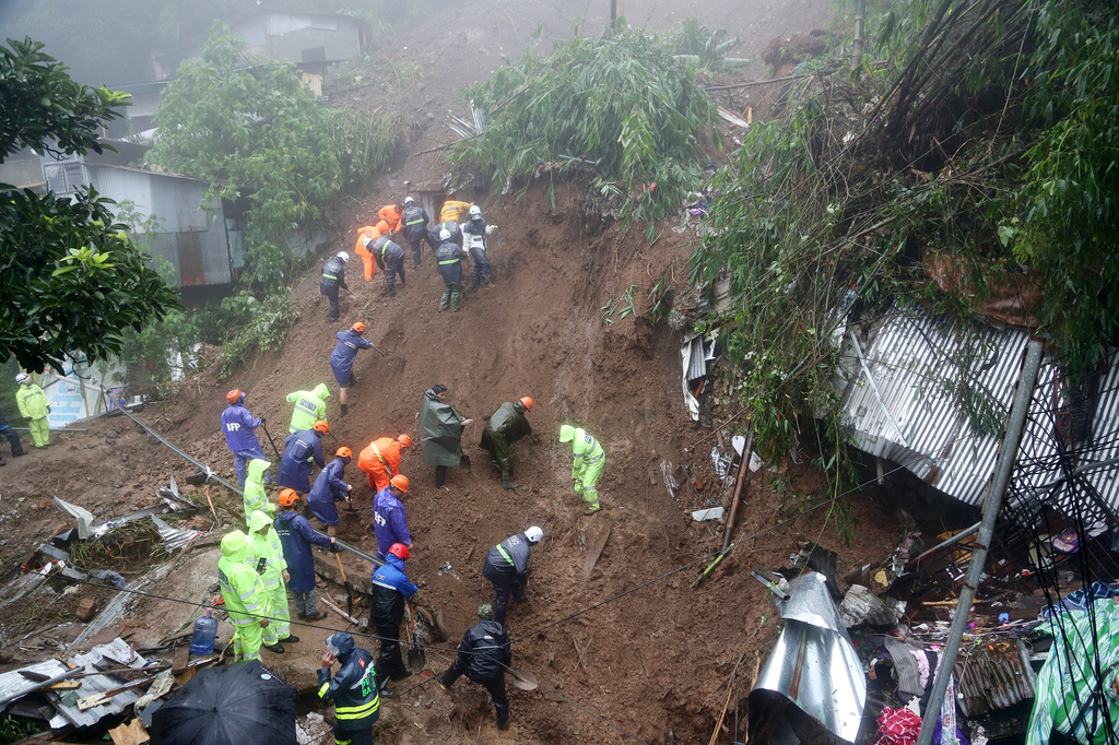 Rescuers conduct search and rescue operations for missing residents a day after several houses were buried from a landslide due to heavy monsoon rains in Guisad Surong, Baguio City, northern Philippines, Monday, Aug. 10, 2026. (AP Photo/Harley Palangchao)