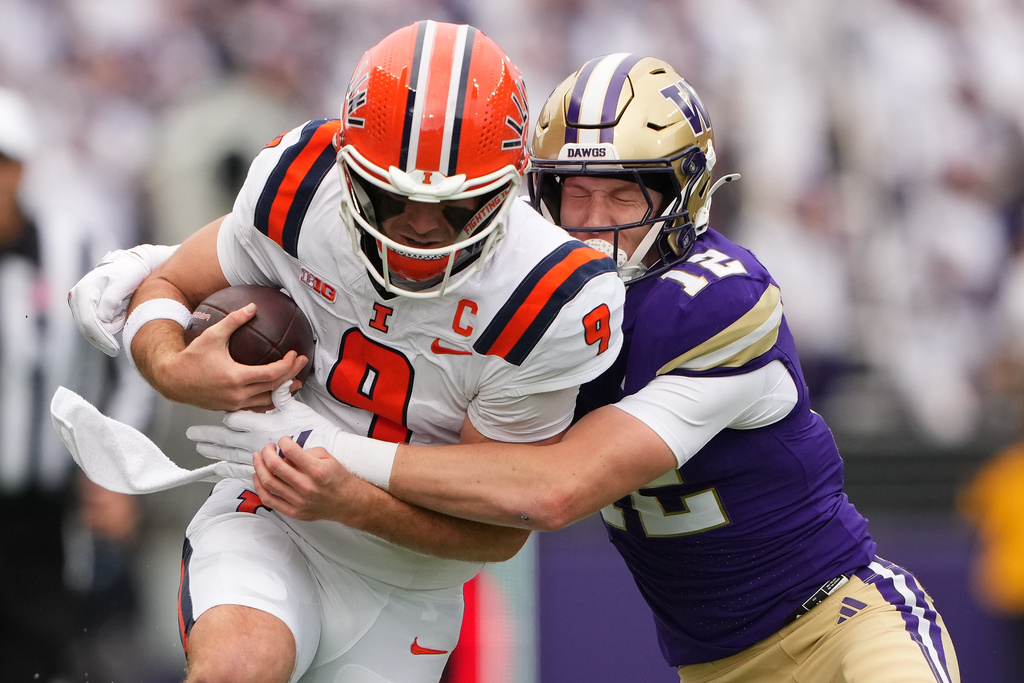 Illinois quarterback Luke Altmyer (9) runs the ball against Washington safety Alex McLaughlin (12) during the first half of NCAA college football game, Saturday, Oct. 25, 2025, in Seattle. (AP Photo/Lindsey Wasson)