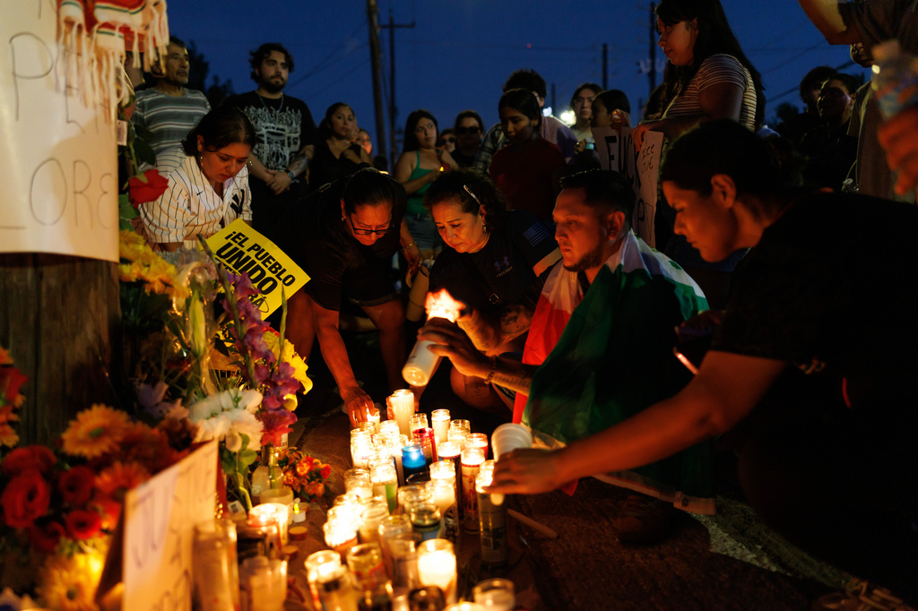 Attendees light candles during a vigil for Lorenzo Salgado Araujo, a Mexican national fatally shot by a federal immigration agent a day prior, Wednesday, July 8, 2026, in Houston. (AP Photo/Mark Felix)