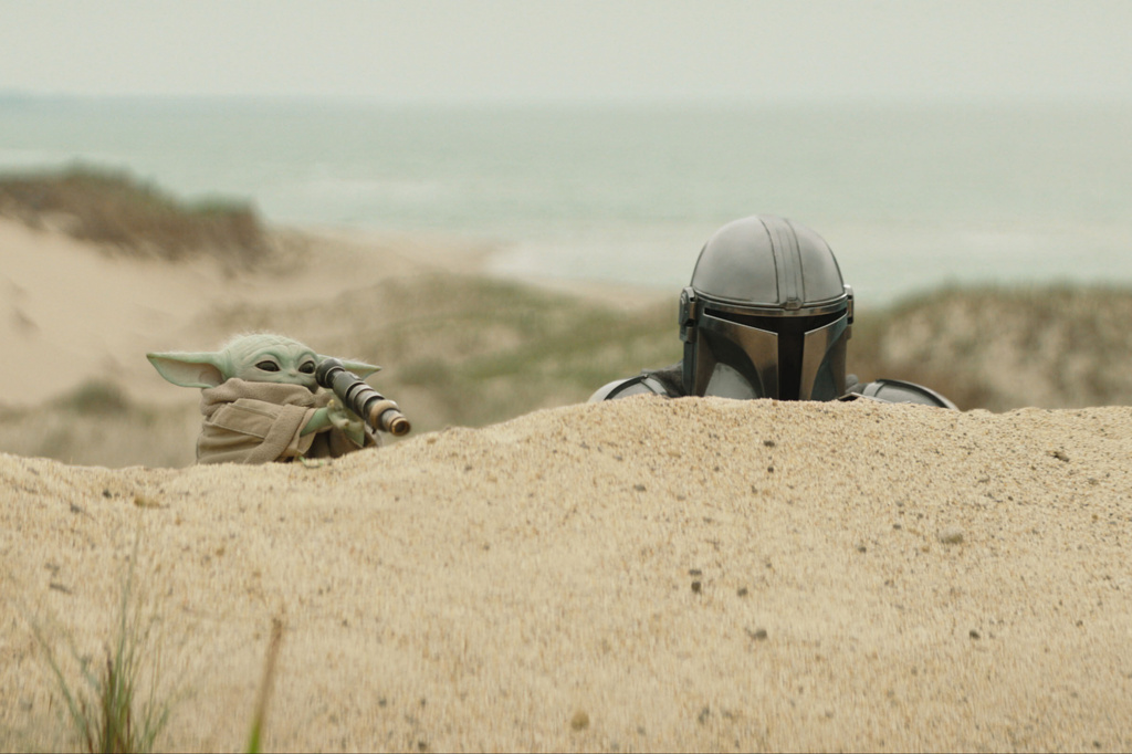 This image released by Disney shows The Mandalorian, portrayed by Pedro Pascal, right, and Grogu in a scene from Lucasfilm's "Star Wars: The Mandalorian and Grogu." (Lucasfilm Ltd. - Disney via AP)